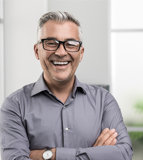 an older man standing and smiling